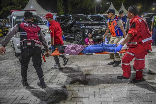Petugas menandu pemudik sepeda motor yang pingsan di Pelabuhan Pelindo Ciwandan, Kota Cilegon, Banten, Sabtu (29/3/2025). Foto: ANTARA FOTO/Galih Pradipta
