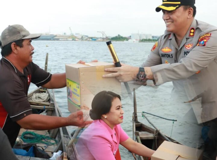 Kapolres Belawan Janton Silaban bersama ketua Bhanyangkara Cabang Pelabuhan Belawan Frisca Janton Silaban saat membagikan Takjil da Sembako kepada Nelayan. Foto: Dok. Polres Pelabuhan Belawan.