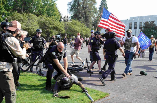 Petugas polisi membubarkan perkelahian antara pendukung Presiden AS Donald Trump dan pengunjuk rasa Black Lives Matter di luar gedung Oregon State Capitol di Salem, Oregon, Portland, Amerika Serikat. Foto: Carlos Barria/Reuters