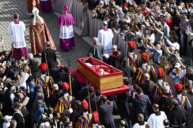 Para pengusung jenazah, di samping Garda Swiss, membawa peti jenazah mendiang Paus Fransiskus (tengah) saat diangkut dari kapel Santa Marta ke Basilika Santo Petrus di Vatikan, Rabu (23/4/2025). Foto: Isabella Bonotto/AFP