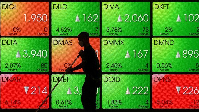 Petugas kebersihan melintas di depan layar pergerakan Indeks Harga Saham Gabungan (IHSG) di Bursa Efek Indonesia, Jakarta. Foto: Puspa Perwitasari/ANTARA FOTO