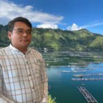Andi Simanjuntak Direktur Eksekutif Sahabat Lingkungan (SALING) Background, Kerambah Jaring Apung (KJA) di Danau Toba. Foto: Ist/Red.